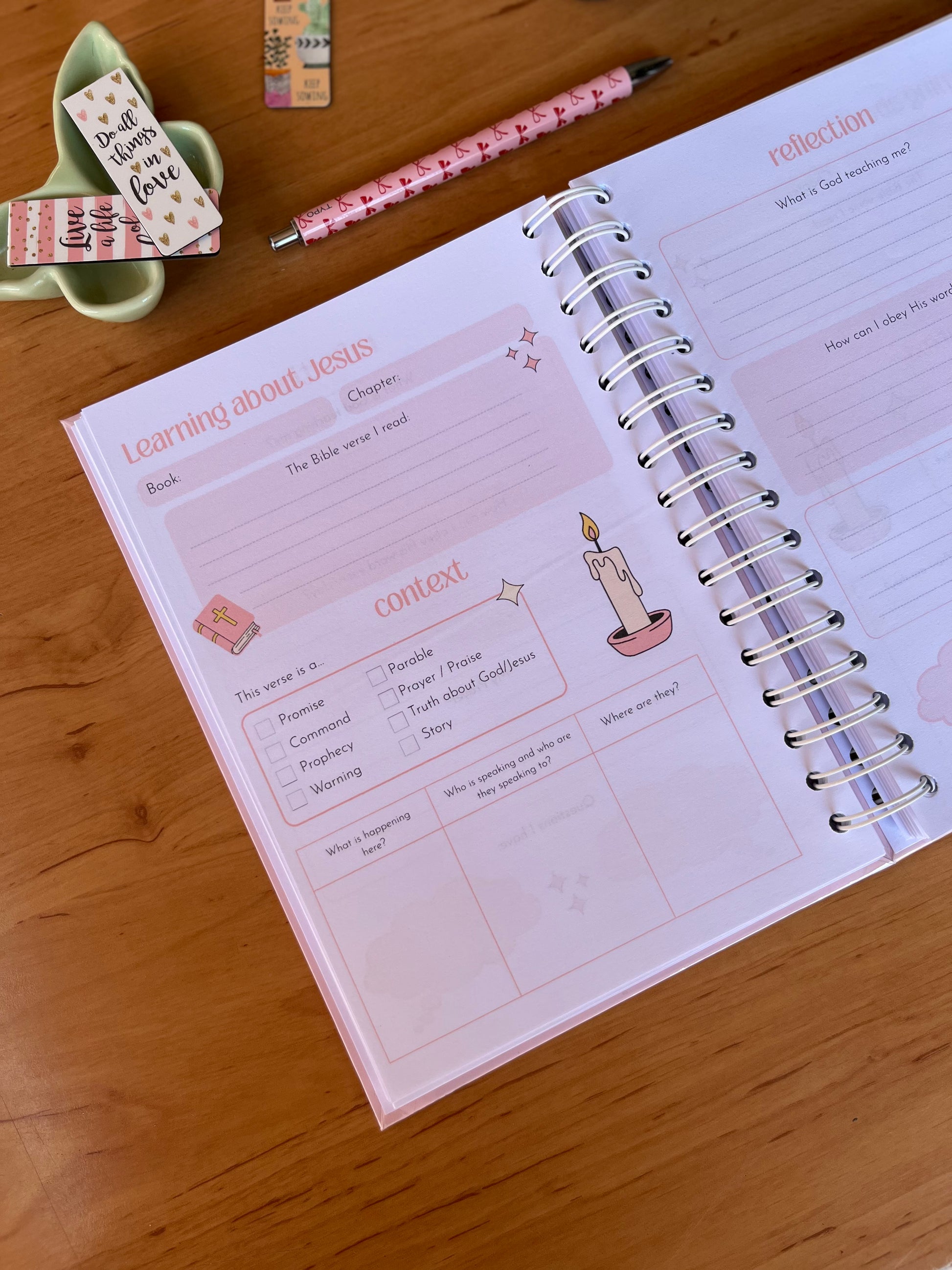 Open Bible Study Journal on a wooden surface with stationery items around