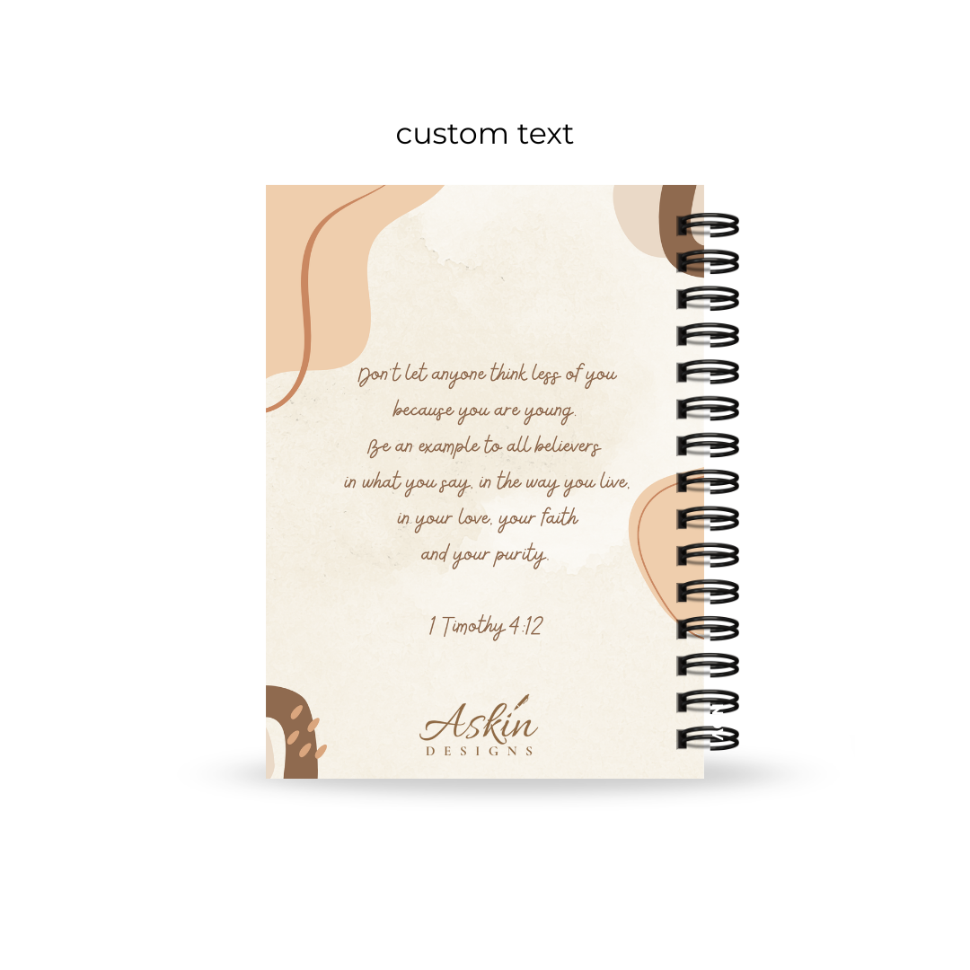 Christian journal with spiral binding and a Bible verse on a white background