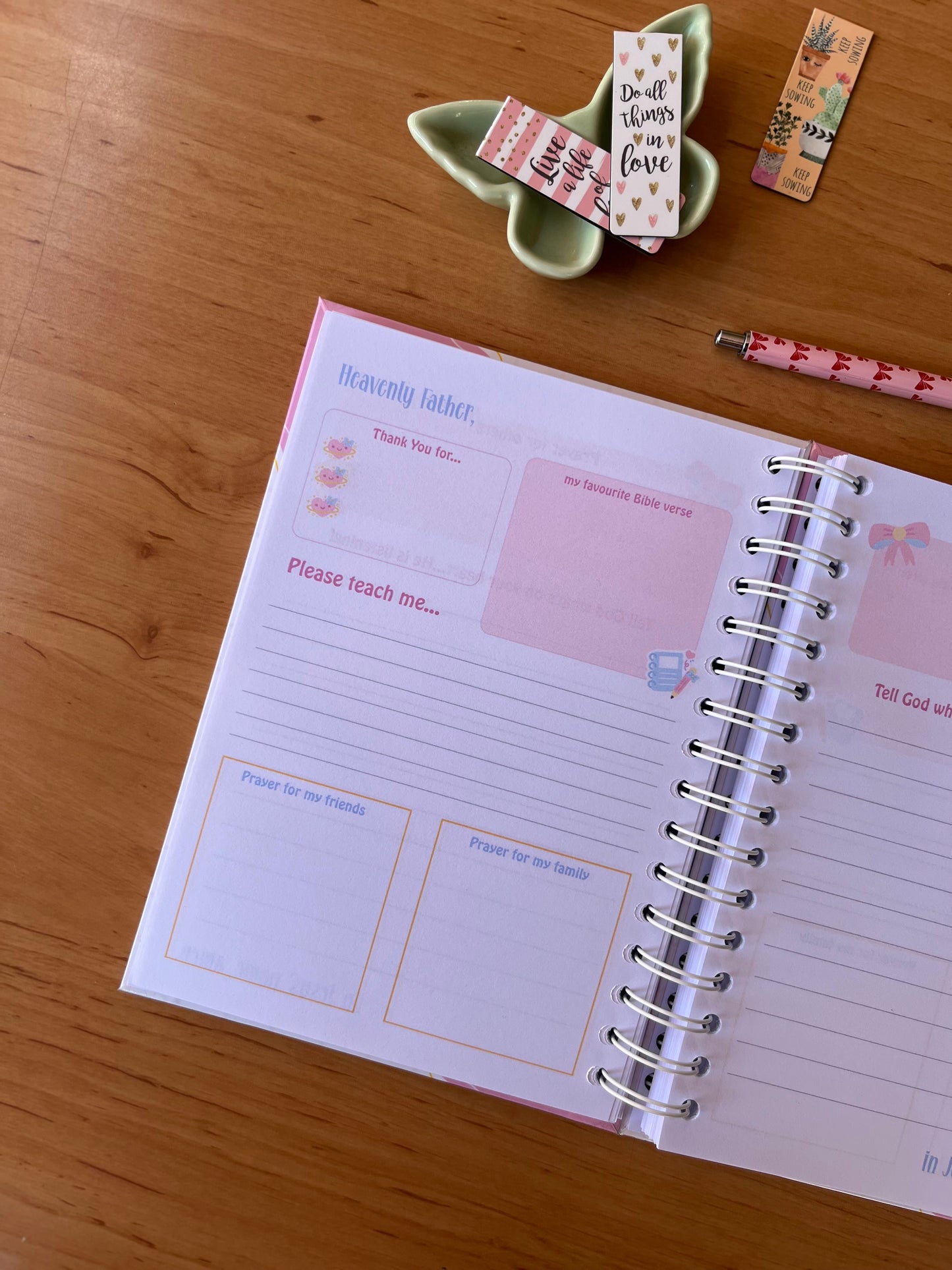 Open prayer Journal on a wooden surface with decorative items around