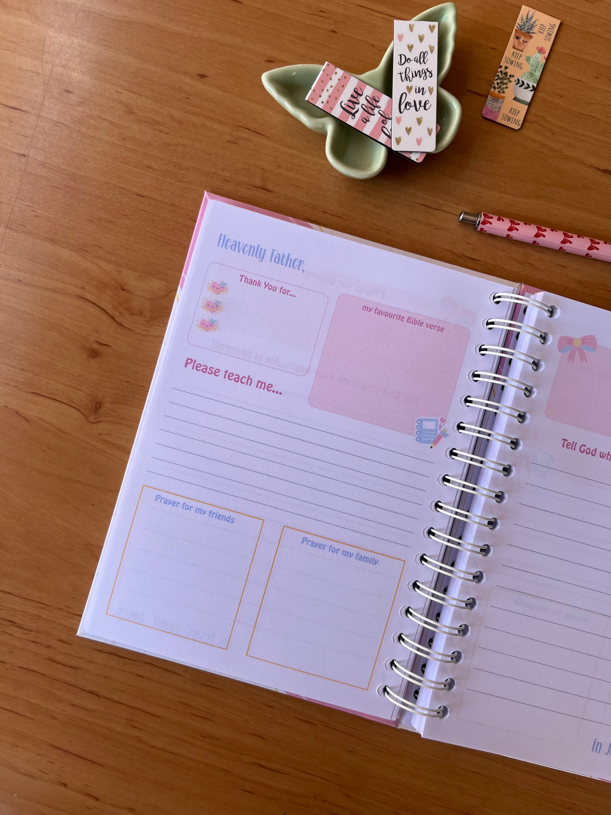 Open prayer Journal on a wooden surface with decorative items around