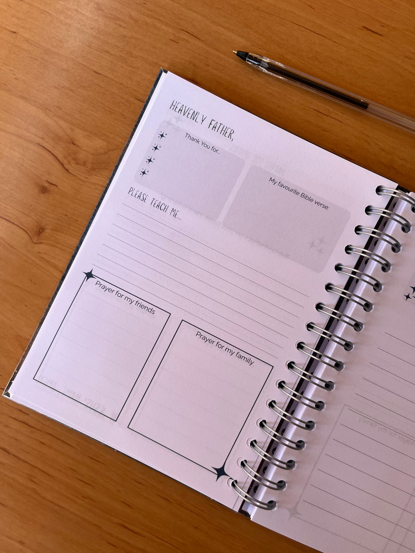 Open prayer journal pages on a wooden surface