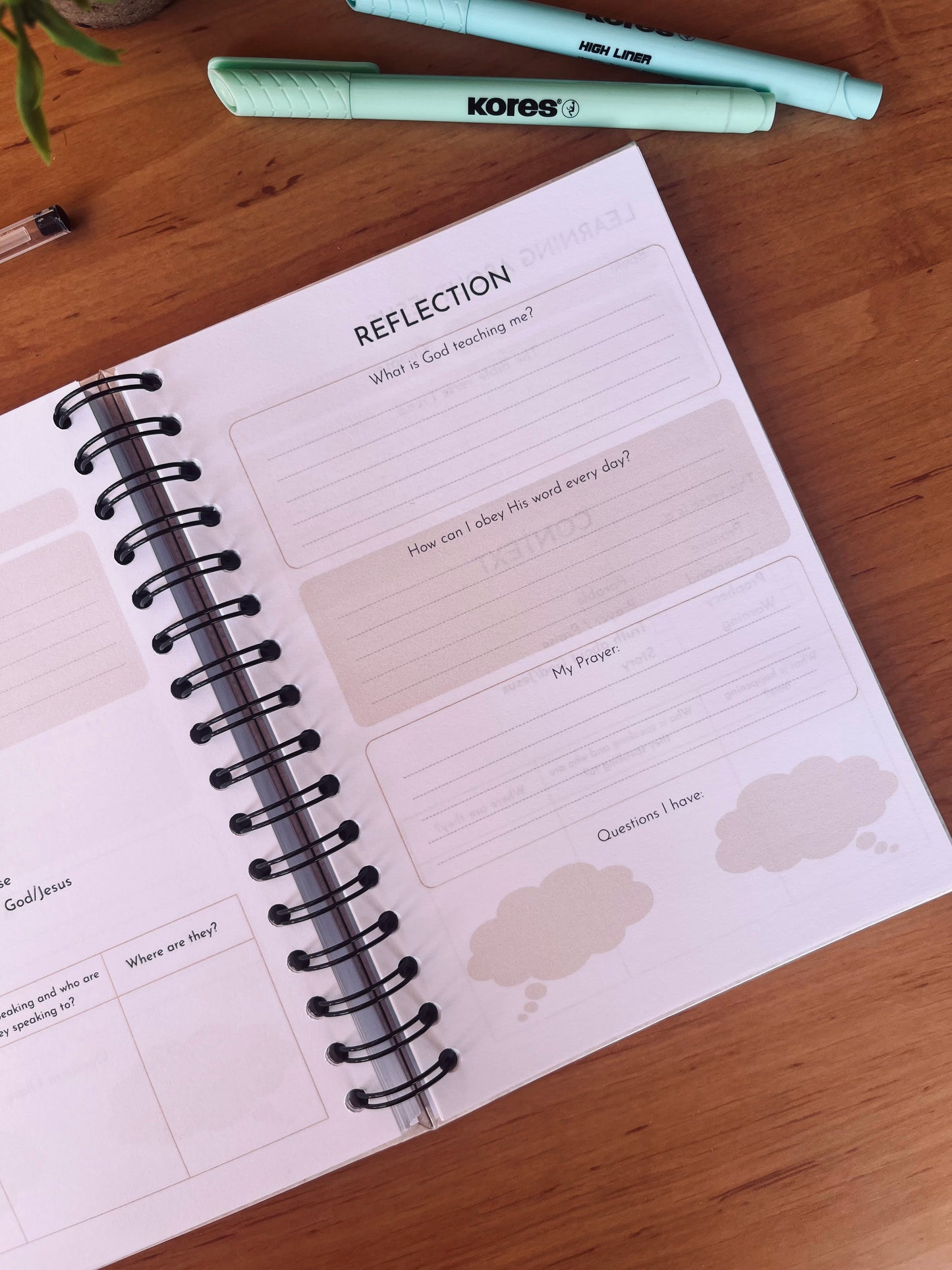 Open Bible Study Journal with reflection section on a wooden surface with markers.